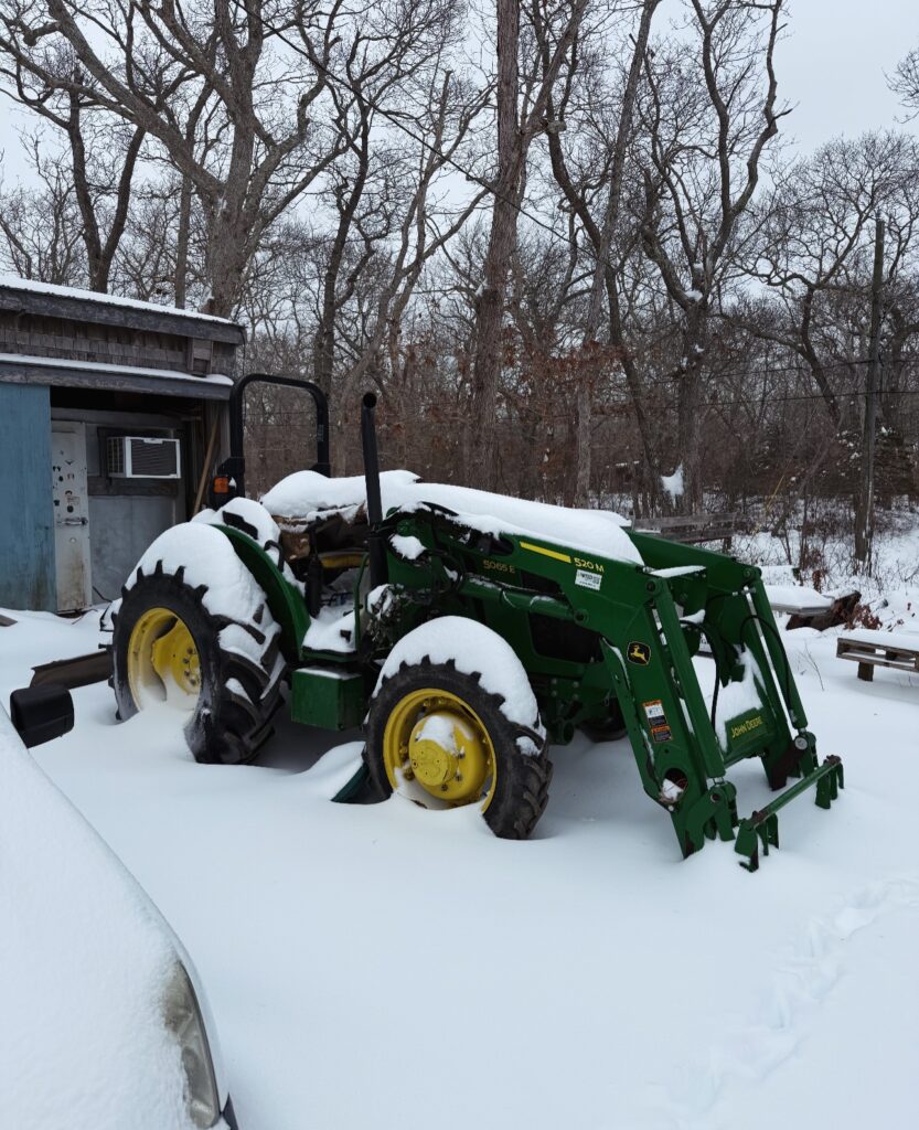 Winter farming at Morning Glory Farm with tractor resting at Crow Hollow Farm under fresh snowfall