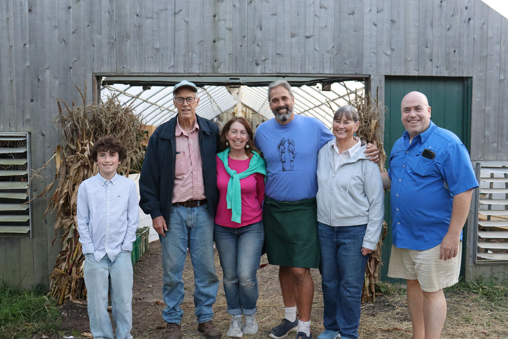Winter to spring at Morning Glory Farm with the family behind the farm standing together at the greenhouse