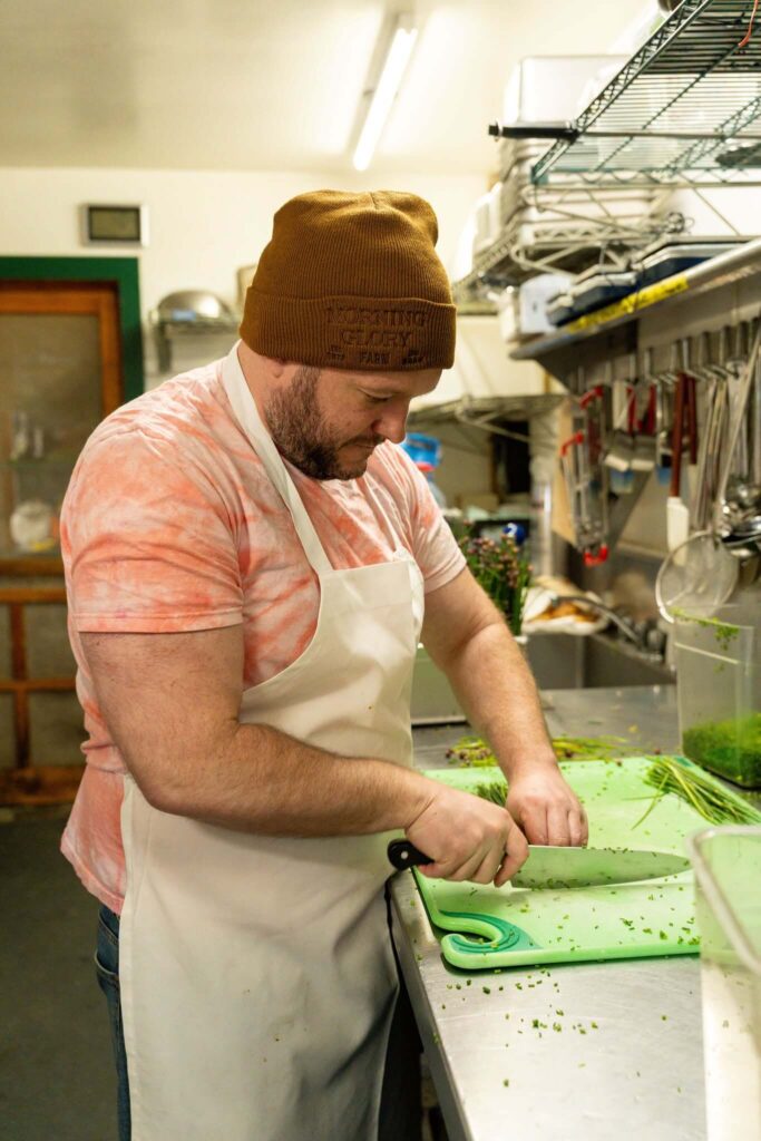 Chef preparing Prepared Farm Fresh Meals using fresh herbs and vegetables at Morning Glory Farm kitchen.