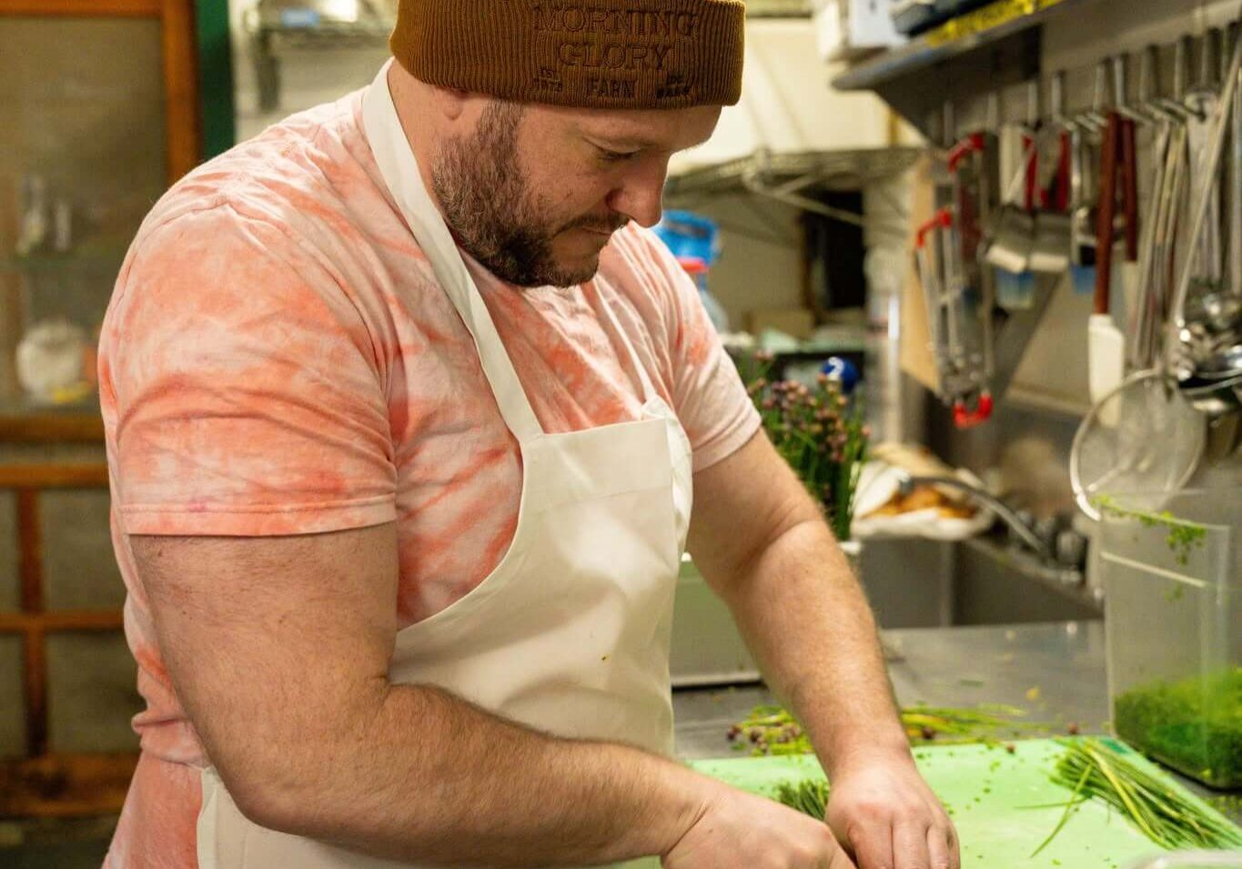 Chef preparing Prepared Farm Fresh Meals using fresh herbs and vegetables at Morning Glory Farm kitchen.