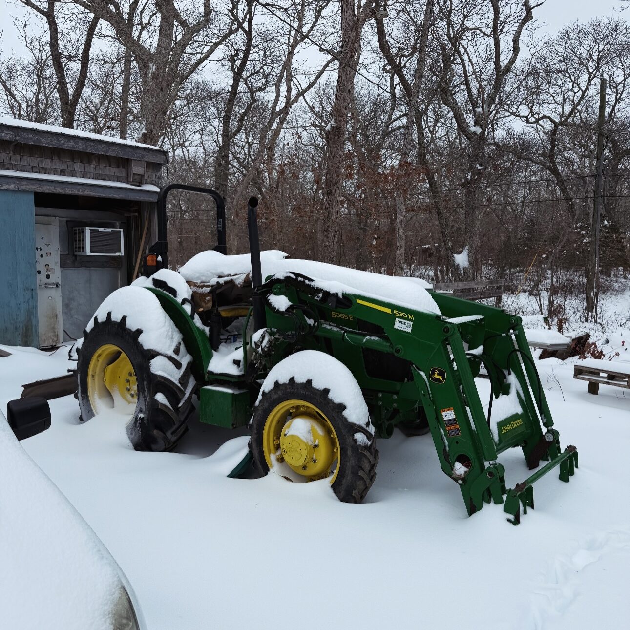 Winter farming at Morning Glory Farm with tractor resting at Crow Hollow Farm under fresh snowfall