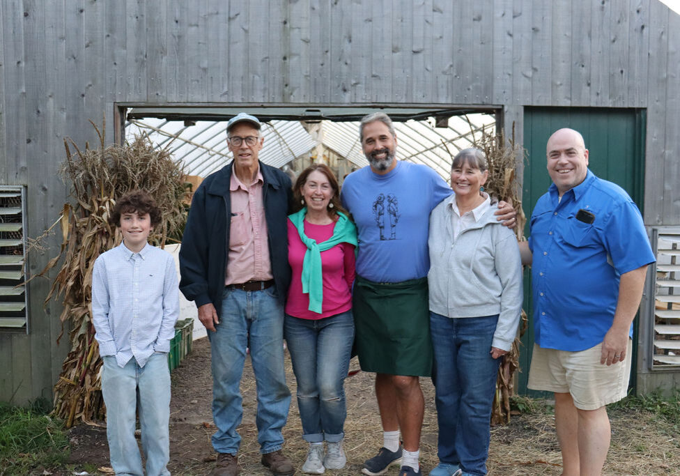 Winter to spring at Morning Glory Farm with the family behind the farm standing together at the greenhouse